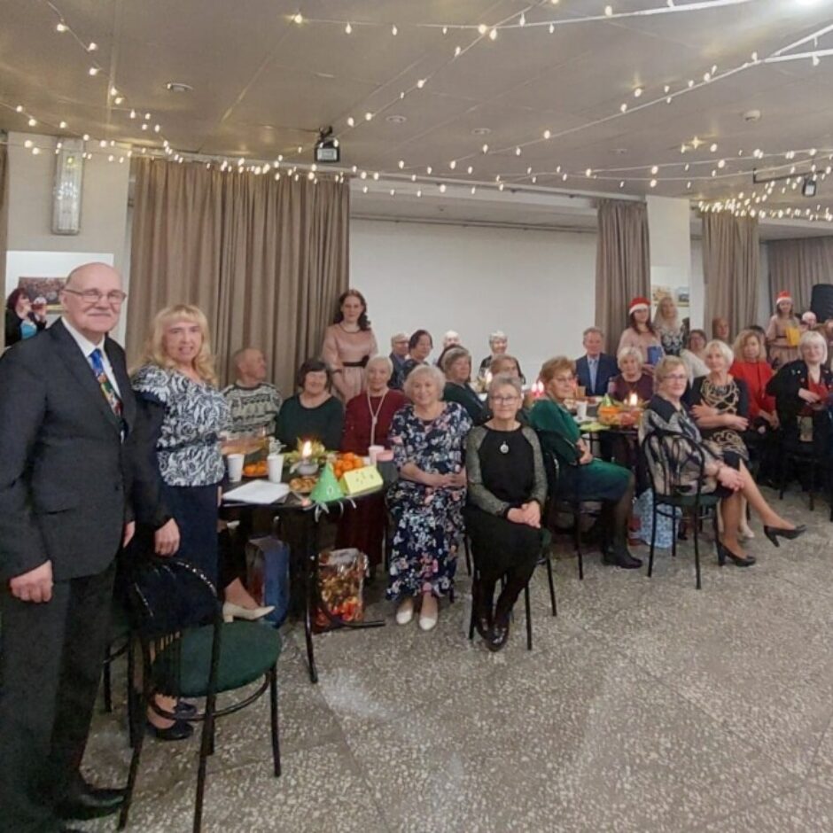 Pensionāri pie galdiņiem klausās priekšnesumus