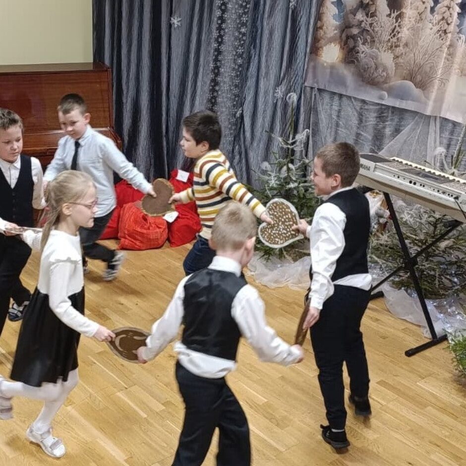 Skolēni sadevušies rokās dejo