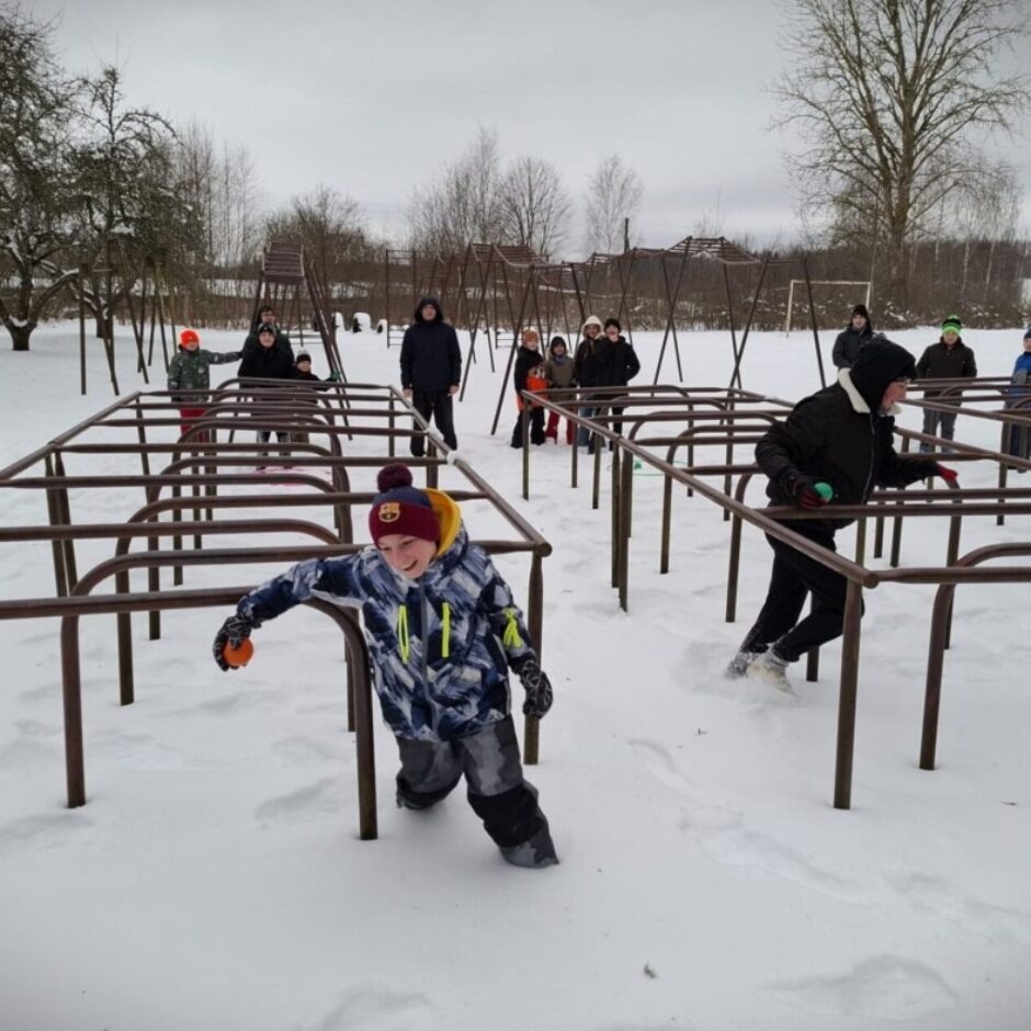 Skolēni veic sbarjeru stafeti sniegā