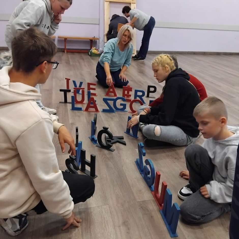 Skolēni veido vārdus no koka burtiem