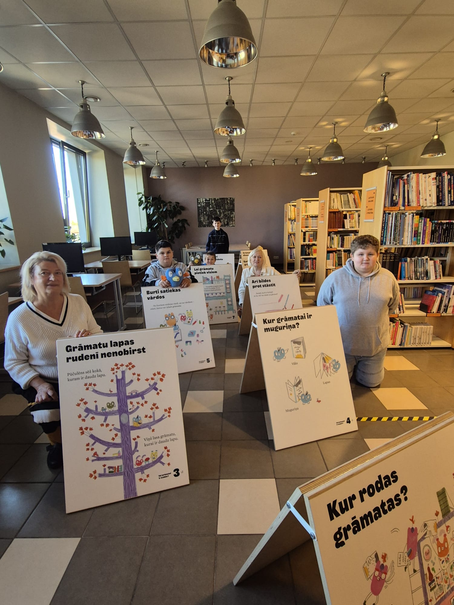 Skolēni un skolotājas bibliotēkā