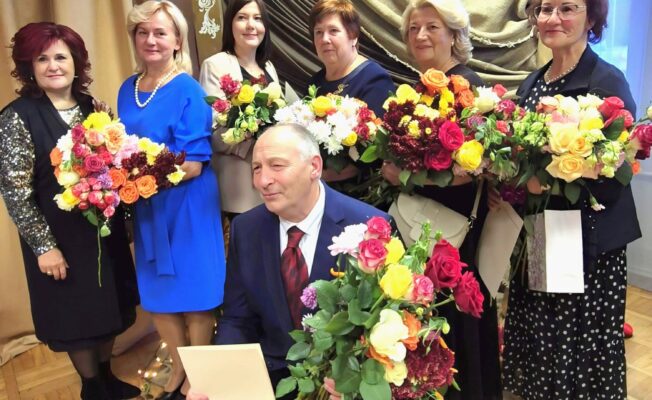 Skolotāji ar goda rakstiem un ziediem