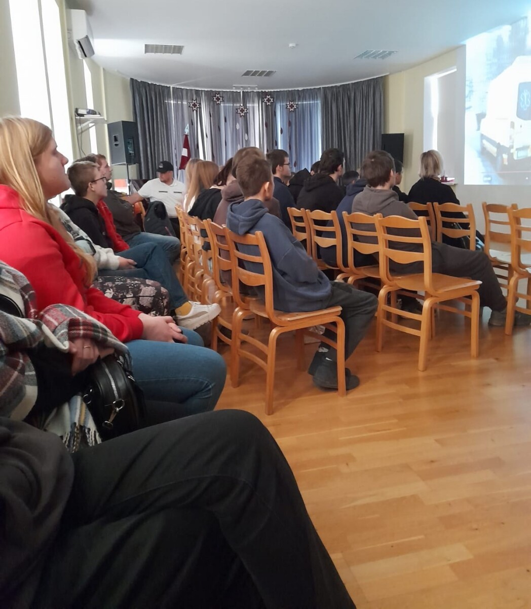 Skolēni sēž zālē un klausās lekciju