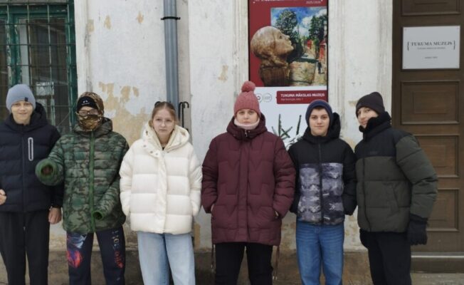 Skolēnu grupa pie muzeja durvīm