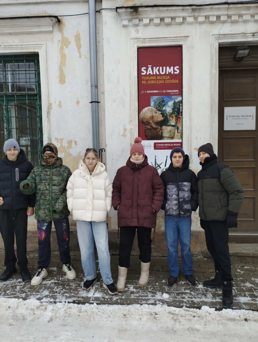 Skolēnu grupa pie muzeja durvīm