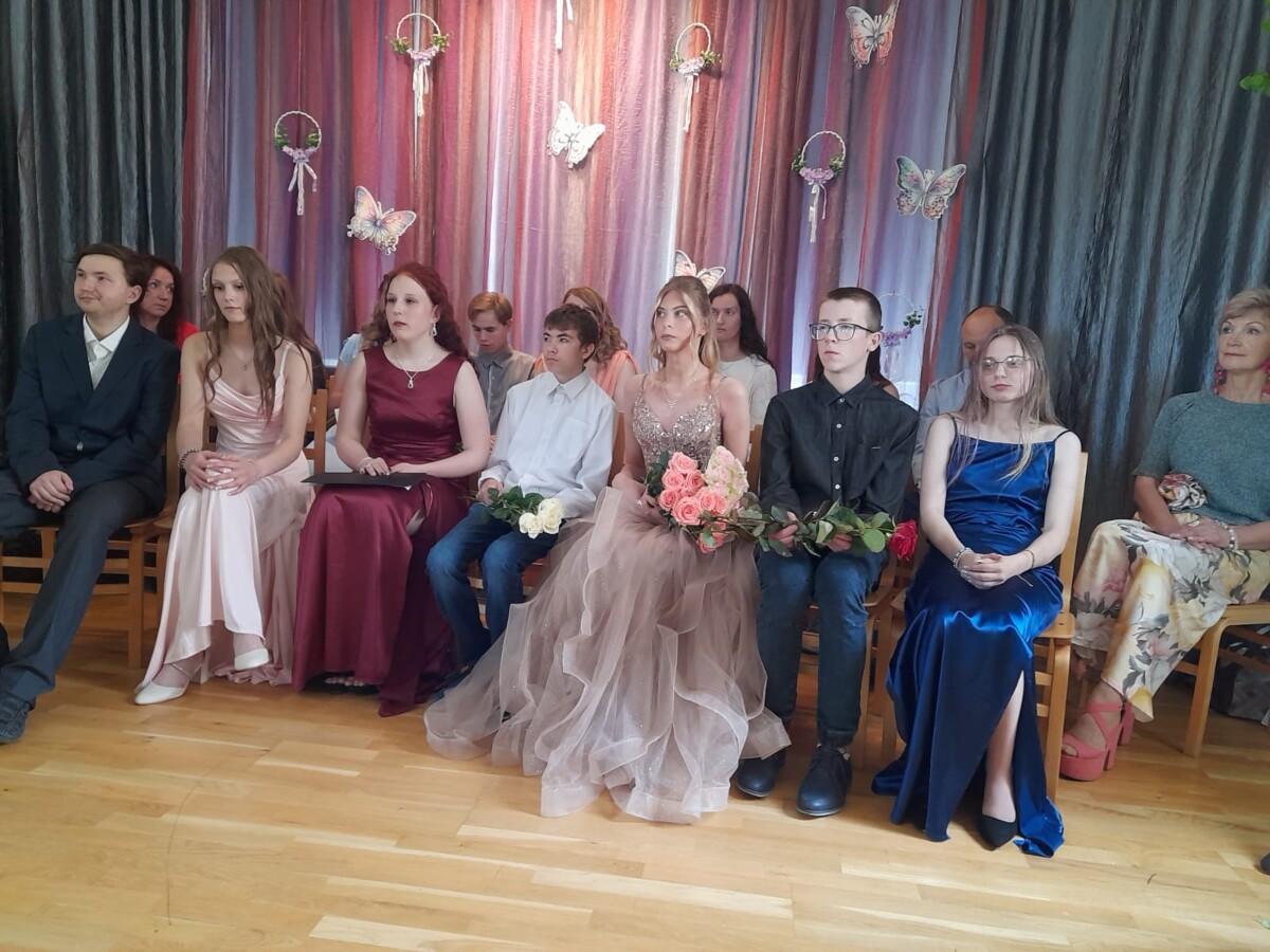 Skolēni sēž skolas zāles priekšā